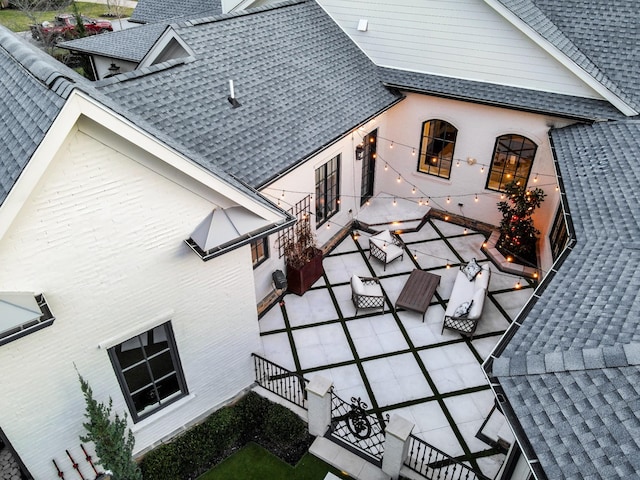 exterior space featuring roof with shingles and a patio