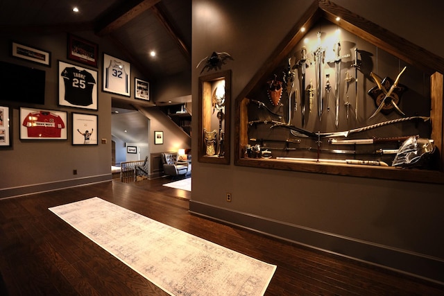 interior space featuring lofted ceiling with beams, hardwood / wood-style flooring, and baseboards