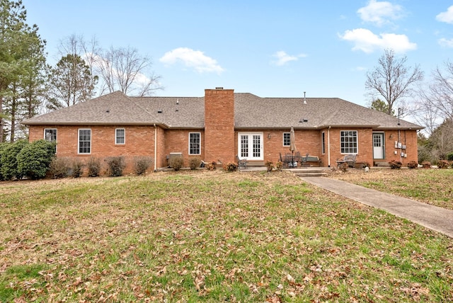 back of property featuring brick siding, a lawn, a chimney, and entry steps