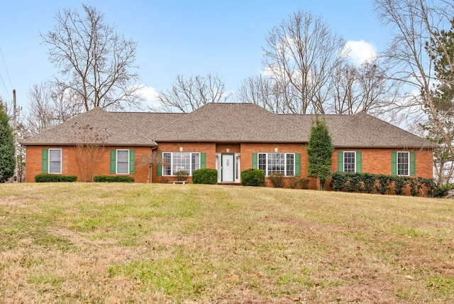 ranch-style house featuring brick siding, a front yard, and roof with shingles