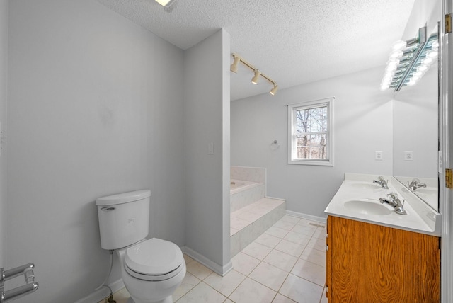 bathroom with a sink, tile patterned flooring, a textured ceiling, a garden tub, and toilet