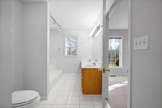 full bath featuring tile patterned floors, toilet, a bathing tub, and a textured ceiling