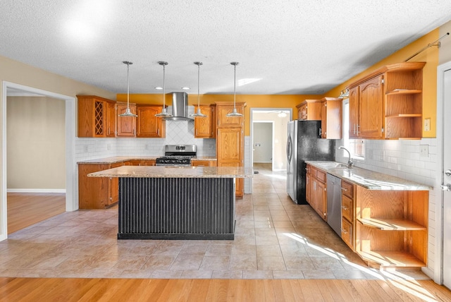 kitchen with open shelves, a center island, wall chimney range hood, stainless steel appliances, and a sink