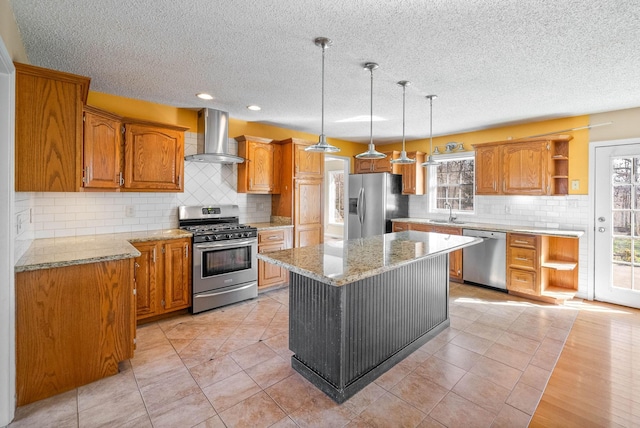 kitchen with open shelves, a sink, a kitchen island, stainless steel appliances, and wall chimney range hood