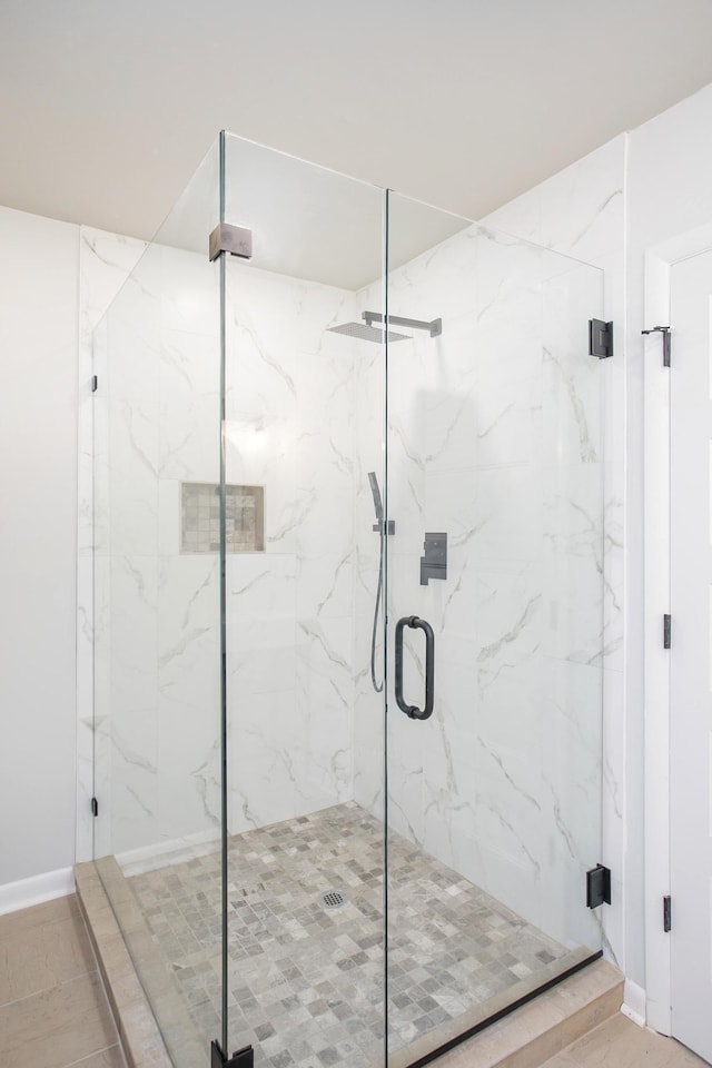 bathroom featuring a marble finish shower