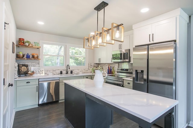 kitchen featuring stainless steel appliances, decorative light fixtures, a sink, and decorative backsplash