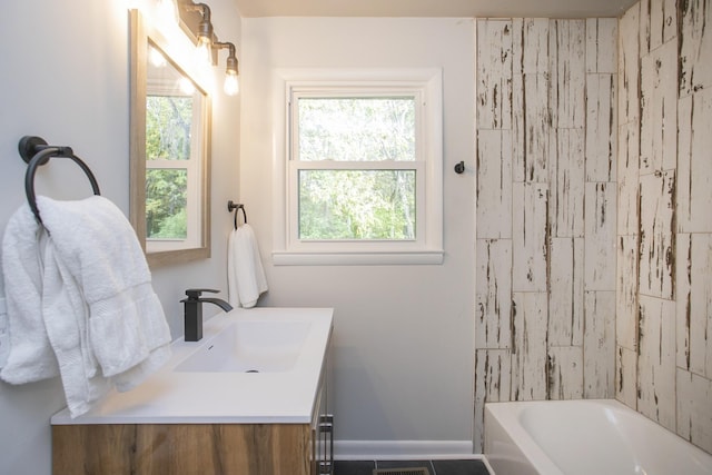 full bathroom featuring washtub / shower combination, baseboards, and vanity