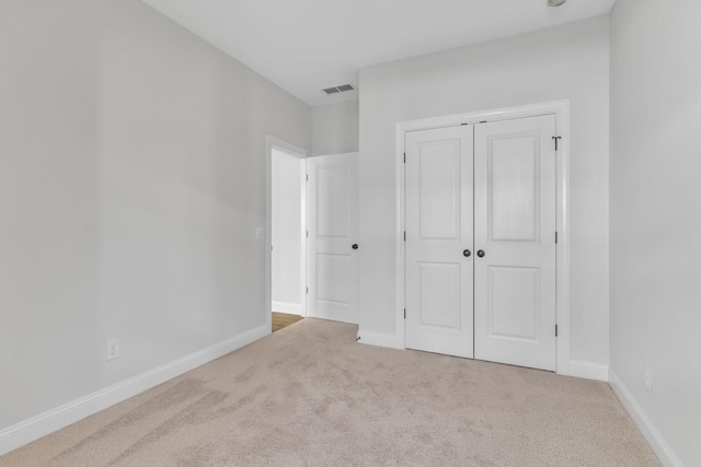 unfurnished bedroom with a closet, baseboards, visible vents, and carpet flooring