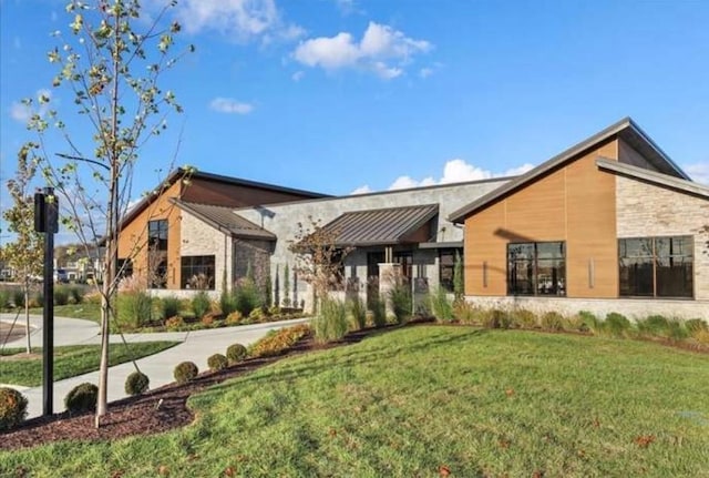 view of front of property with stone siding and a front yard