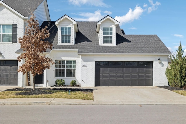 view of front facade featuring a garage, brick siding, concrete driveway, and roof with shingles