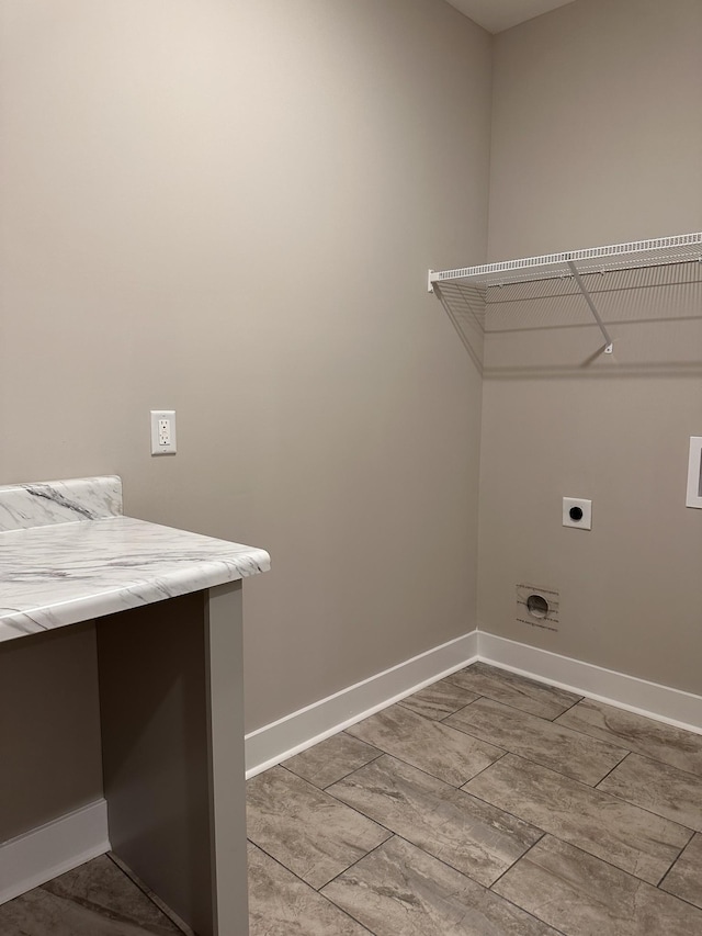 clothes washing area with laundry area, baseboards, and electric dryer hookup