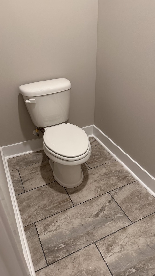 bathroom with baseboards and toilet