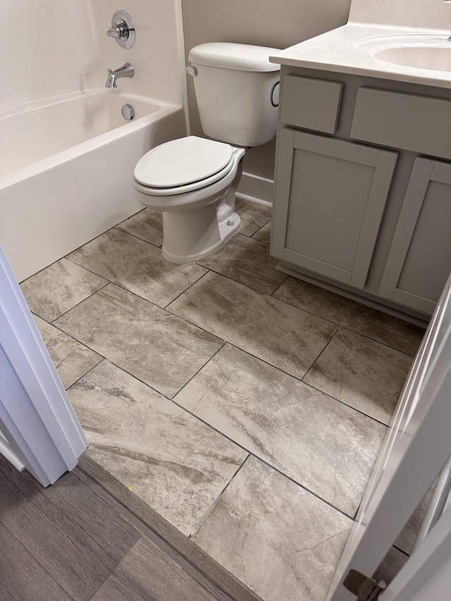 bathroom with vanity, toilet, and baseboards