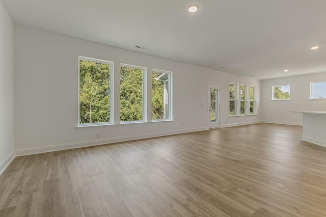 unfurnished living room with baseboards, light wood-type flooring, visible vents, and recessed lighting