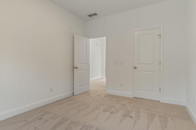 empty room with carpet floors, baseboards, and visible vents