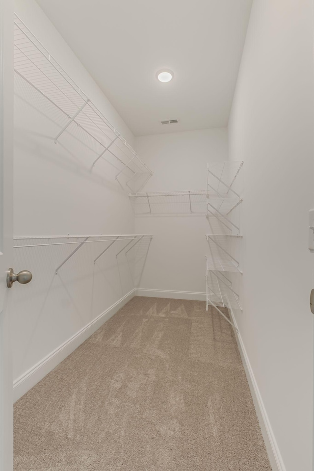 spacious closet featuring light colored carpet and visible vents