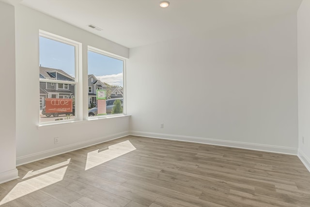 unfurnished room featuring light wood-style flooring, visible vents, baseboards, and recessed lighting