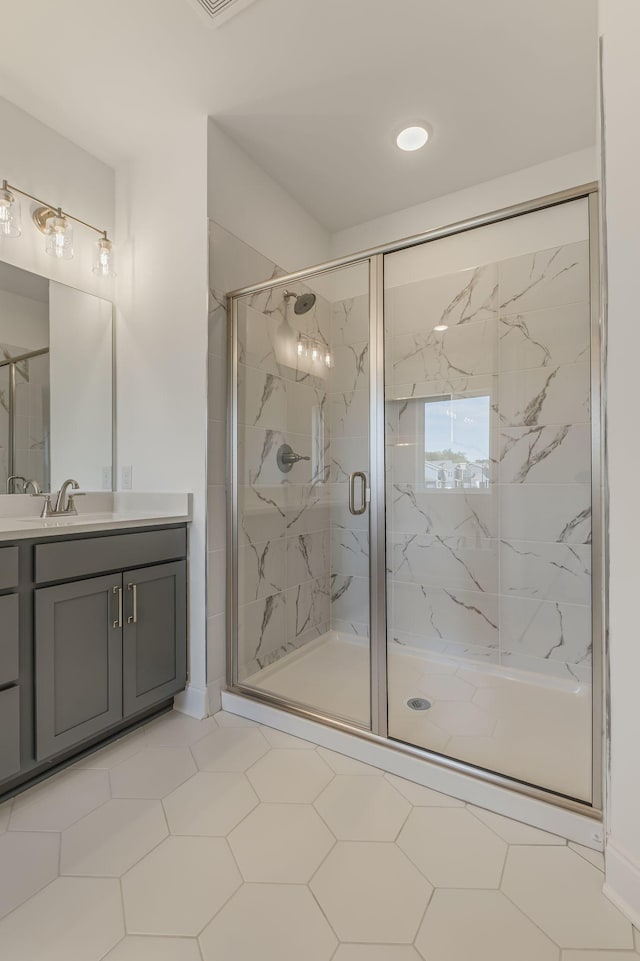 bathroom with a marble finish shower and vanity