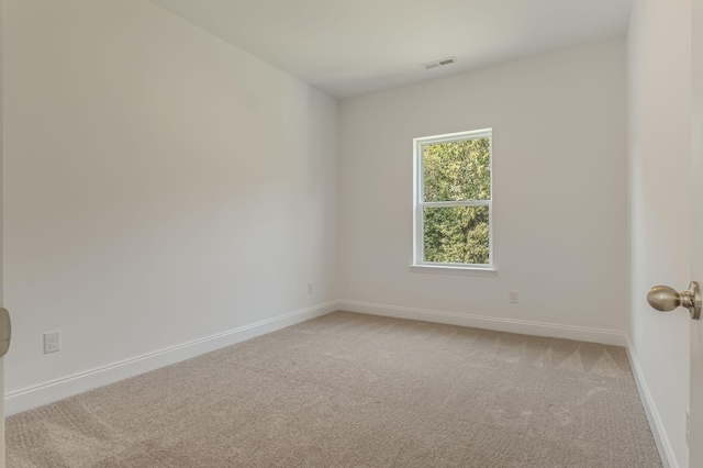 unfurnished room featuring baseboards, visible vents, and light colored carpet