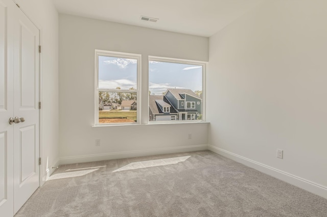 unfurnished bedroom featuring carpet floors, baseboards, and visible vents