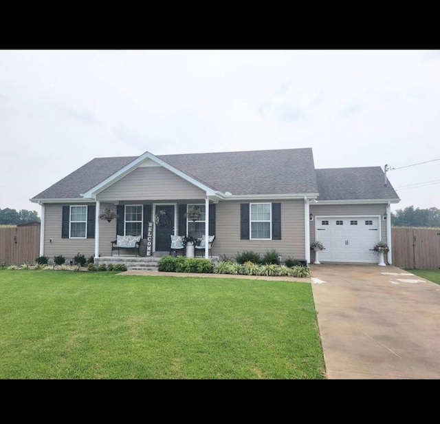 ranch-style house featuring an attached garage, covered porch, fence, driveway, and a front yard