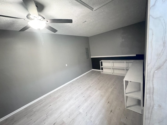 unfurnished bedroom with a textured ceiling, wood finished floors, a ceiling fan, and baseboards