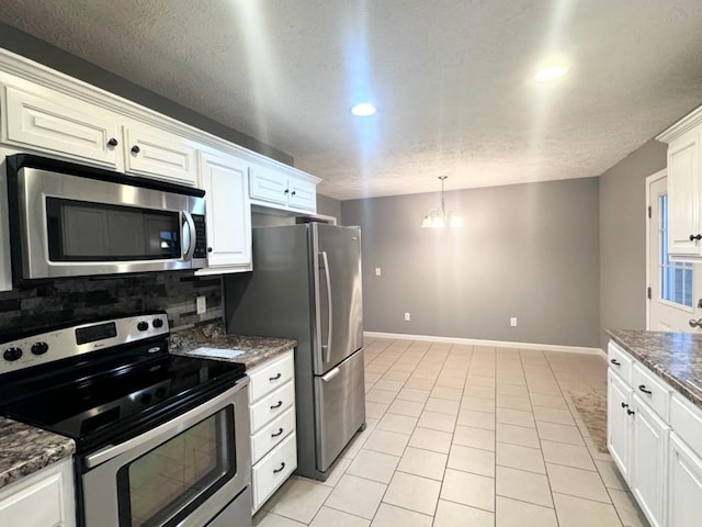 kitchen with light tile patterned floors, baseboards, appliances with stainless steel finishes, backsplash, and an inviting chandelier