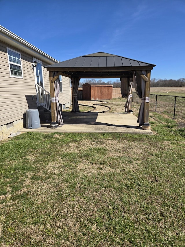 view of yard with a patio, a storage unit, a gazebo, and fence