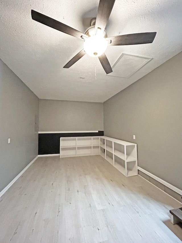 additional living space with baseboards, a textured ceiling, ceiling fan, and wood finished floors