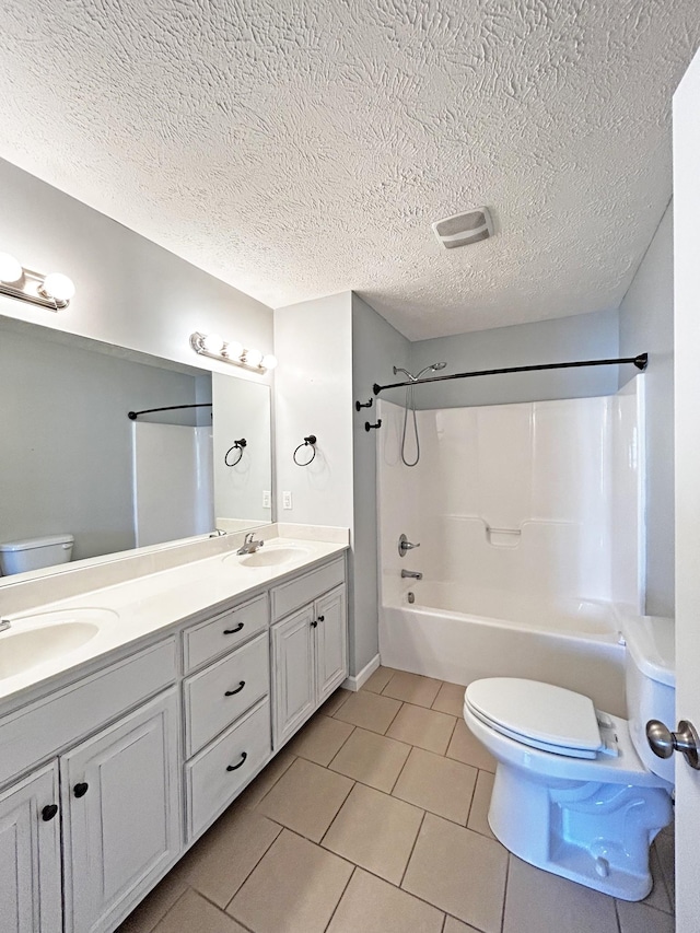 bathroom with a sink, toilet, double vanity, and tile patterned flooring