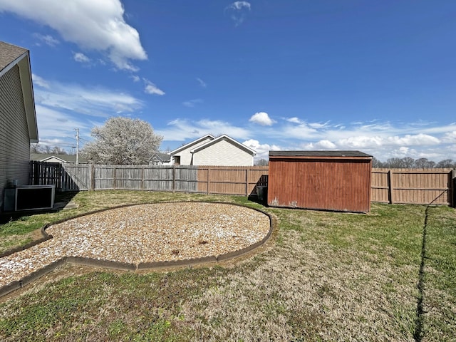 view of yard with an outbuilding, a storage unit, and a fenced backyard