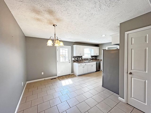 kitchen with dark countertops, visible vents, a notable chandelier, white cabinets, and stainless steel appliances