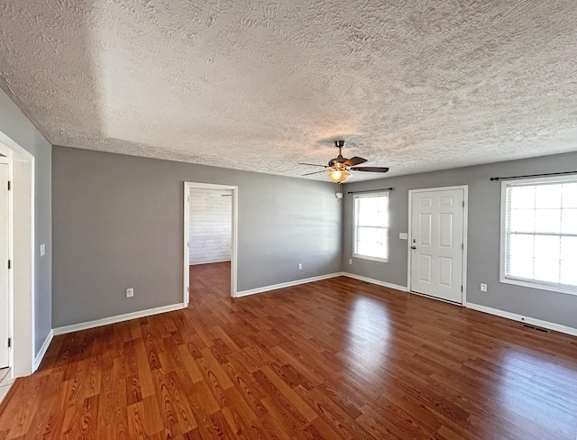 interior space featuring baseboards, wood finished floors, visible vents, and ceiling fan