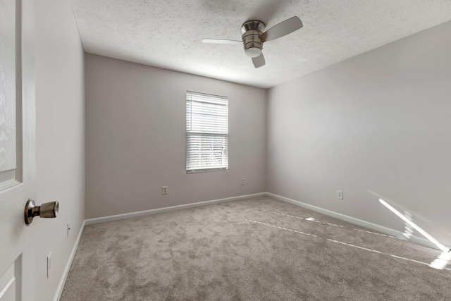 carpeted empty room featuring a textured ceiling, ceiling fan, and baseboards