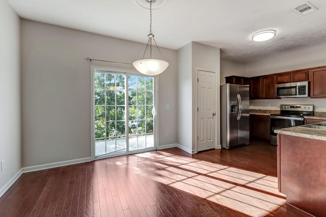 kitchen featuring baseboards, visible vents, dark wood-style floors, stainless steel appliances, and pendant lighting