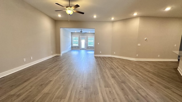 unfurnished living room with baseboards, a ceiling fan, dark wood-style flooring, and recessed lighting