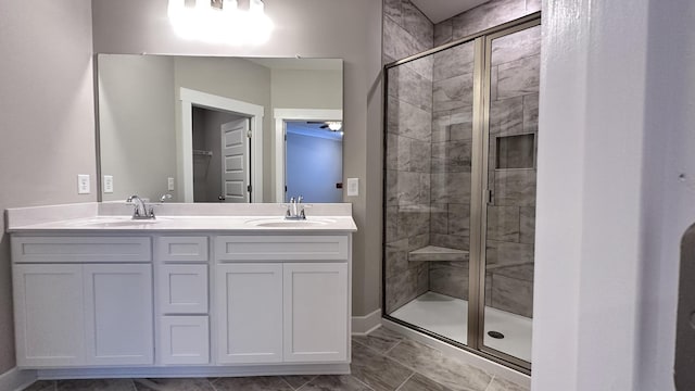 full bath featuring double vanity, a stall shower, and a sink