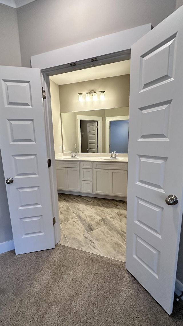 bathroom with double vanity, carpet flooring, and a sink