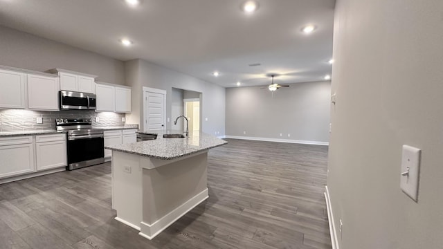 kitchen featuring backsplash, appliances with stainless steel finishes, white cabinets, a sink, and ceiling fan