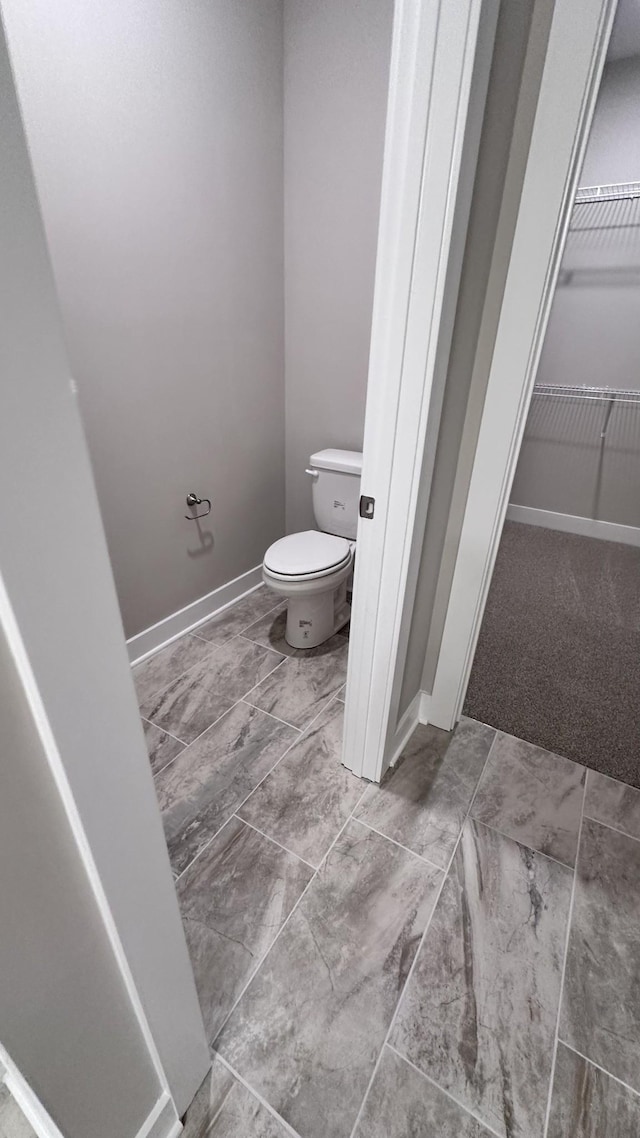 bathroom featuring baseboards and toilet