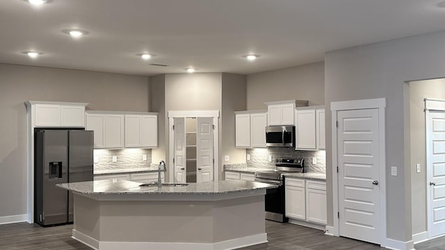 kitchen featuring dark wood-style floors, a kitchen island with sink, stainless steel appliances, and a sink