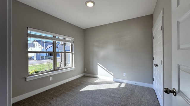 carpeted empty room with baseboards