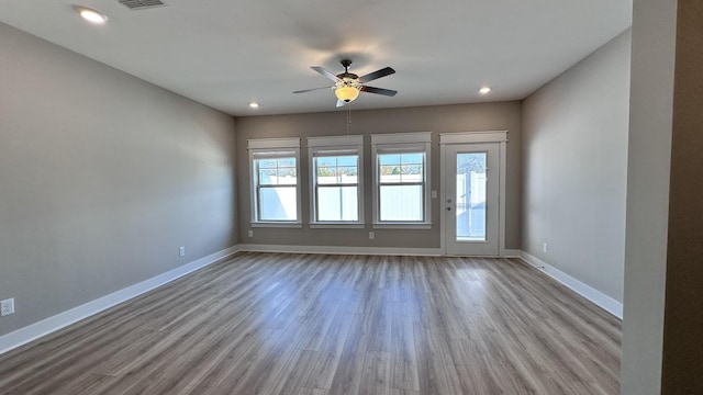 empty room with a ceiling fan, recessed lighting, baseboards, and wood finished floors