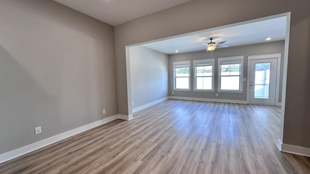 spare room with a ceiling fan, baseboards, and wood finished floors