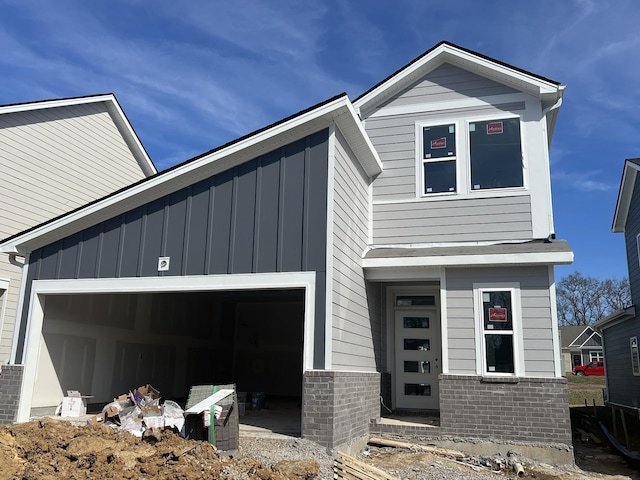 view of front facade featuring board and batten siding, brick siding, and a garage