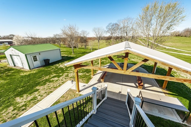 wooden deck featuring a lawn and an outdoor structure