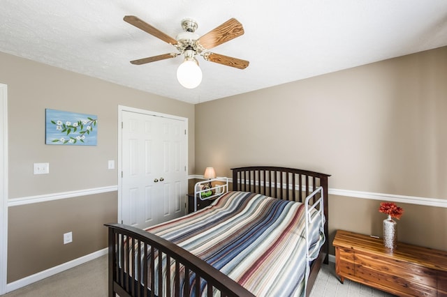 bedroom featuring a ceiling fan, a closet, light carpet, and baseboards