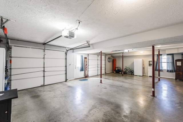 garage featuring a garage door opener and freestanding refrigerator