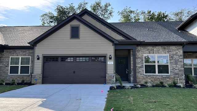 craftsman-style house featuring a shingled roof, concrete driveway, an attached garage, a front lawn, and board and batten siding