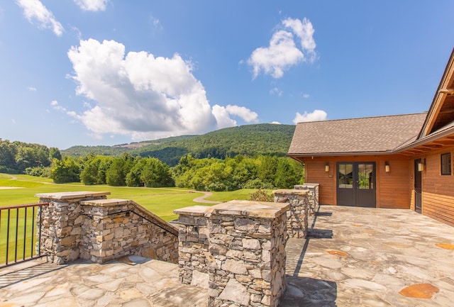 view of patio / terrace featuring a wooded view and a mountain view